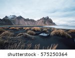 Beautiful sunset black sand beach in Iceland with huge dunes and atlantic ocean. Vestrahorn mountain on the background