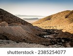 Small photo of Road in the moroccan Andes mountains with a twisty road and valley with fog. MDC23 Morocco