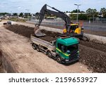 Small photo of A heavy plant digger machine loading a tipper lorry with spoil from a railway engineering sidings