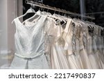 Beautiful bridal dress on hangers. Wedding dress close up at the wedding salon. Wedding dresses hanging on a hanger. Interior of bridal salon.