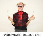 lonely young woman posing near white wall with lighting sparklers. girl  has written 2021 on forehead. celebrating silvester or new year  at home quarantine. lockdown.
