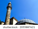 stone turkish minaret and mosque in Pecs, Hungary. diminishing perspective. low angle view. islamic arrchitecture. landmark building. named after Jakovari Hassan. blue sky. travel and architecture.