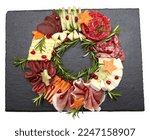 Small photo of Appetizers boards with assorted cheese, meat, grape and nuts. Charcuterie and cheese platter. Top view on white background. Christmas wreath