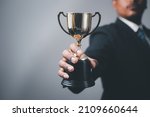 Small photo of Businessman, success, company president Holding an outstanding trophy for corporate development of an investment company