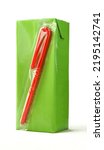 Small photo of Green carton juice box with red plastic straw attached isolated on white background