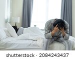 Asian young male feel angry boyfriend having conflict domestic problem. New marriage man and woman feel heartbroken for quarrel conflict while sit on bed in bedroom. Family problem-separation concept.