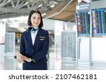 Small photo of Portrait of Caucasian flight attendant standing in airport terminal. Attractive beautiful cabin crew or air hostess woman smiling and looking at camera with confidence before walk to airplane for work