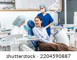 Small photo of Caucasian dentist examine tooth for young girl at dental health clinic. Attractive woman patient lying on dental chair get dental treatment from doctor during procedure appointment service in hospital
