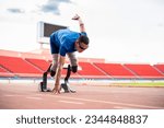 Asian para-athletes disabled with prosthetic blades running at stadium. Attractive amputee male runner exercise and practicing workout for Paralympics competition regardless of physical limitations