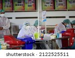 Small photo of Thailand : February 13, 2022 - Public health workers wearing PPE are doing Rapid antigen test on people, using Kheha Thung Song Hong Wittaya School 2 Bangkok as an ad hoc service point.