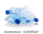 Mineral water bottles crushed and crumpled against white isolated background