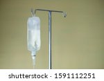 Small photo of Saline solution bag hanging near bed in hospital room. Saline drip is for sick patient. Health insurance is an option for paying medication or admission fee. Illness & Hospital healthcare concept.