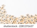 wooden squares with alphabet letters lying in random order, copy space, background