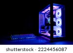 Small photo of Water Cooled Gaming Pc with RGB rainbow LED lighting. Modern gaming computer with a keyboard in a dark room. Water Liquid Cooling Computer