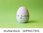 white egg timer on green background. Happy Easter in the kitchen. Home related, home staying. Free copy space. Flat lay, top view