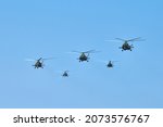 Military helicopters flying in bright blue sky performing demonstration flight, airforce, copy space. Group combat helicopters, aerobatic team performs flight at air show