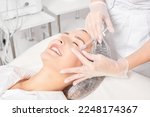 Cosmetologist makes rejuvenation injection in woman face skin, anti aging revitalization cosmetic procedure in beauty spa salon. Beautician hands in gloves makes facial acid injection treatment