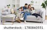 Small photo of Caucasian parents with kids on couch using gadget. Young man and woman with son and daughter spending time together with laptop. Father and mother watching something online on computer. Rest at home.