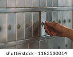 Small photo of Close up of a female hand opening a mailbox with a small key - post office box or PO BOX concept - bank deposit box