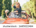 Three girls best friends enjoying summer trip in Tuscany with red vintage car
