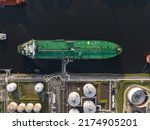Small photo of Petrochemical energy heavy transport industry cargo vessel tanker top down aerial drone view. Docked bulk carrier ship along storage facility silos. Energy gas and lpg petroleum commercial industry.