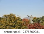 Small photo of SEOUL, SOUTH KOREA - OCTOBER 26, 2022: Kim Gu (Kim Koo) statue raises his right hand at Baekbeom Plaza in Namsan Mountain Park with colourful trees foliage in Autumn.