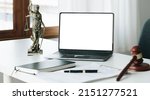 Small photo of Workspace of lawyer with laptop blank white screen and law wooden gavel,legal book and brass scale of judge. lawyer and law ,judiciary and legislature courtroom legal concept.