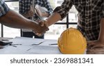 Small photo of A team of engineers who successfully planned work on a modern home construction project shook hands and congratulated the team on their success.