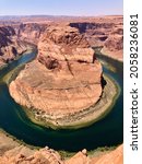 Small photo of Horseshoe Bend is the name of the place where the Colorado River entrenched in the shape of a horseshoe near the town of Page, Arizona, United States.The boat floating on the river looks small.