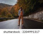 lonely man on road, concept of loneliness, depression, thoughtfulness. Autumn, mountains, beautiful background. Abstraction path to oneself, feeling of soul, cloudy bad weather.