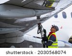Small photo of Vilnius Lithuania 2021-08-24 An employee of the ground service of the airport operating the tanker refills the aircraft with aviation fuel.