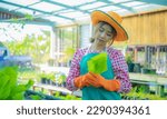 Small photo of Beautiful asian farmer commitment to the environment and organic vegetables is reflected in her farming practices which eschew harmful pesticides and chemicals, Smart farm.