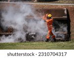 Small photo of The image of the firefighter gripping the fire hose amidst the swirling smoke showcases their courage and selflessness highlighting his willingness to confront danger head on.