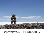 Inukshuk or Inuksuk landmark with frozen bay in the background near Arviat, Nunavut