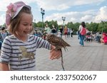 Girl holding small owl while...