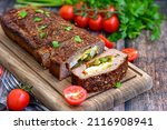Small photo of Home made baked delicious German meatloaf (Falscher Hase or Hackbraten) is a traditional pork and beef meat loaf bound with boiled eggs and cucumbers