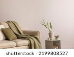 Minimalist composition of elegant and outstanding space with beige sofa, coffee table, vase, green plaid and pillow. Beige wall. Home decor. Template. 