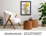 Small photo of Interior design of harmonized living room with mock up poster frame, stylish white armchair, lamp, wooden coffee table, decoration and personal accessories. Beige wall. Home decor. Template.