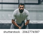 Small photo of Beautiful man playing paddle tennis, racket in hand concentrated look. Young sporty boy ready for the match. Focused padel athlete ready to receive the ball. Sport, health, youth and leisure concept