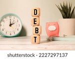 Small photo of Wooden blocks with the word Debt. Reduction or restructuring of debt. Refusal to pay debts or loans and invalidate them
