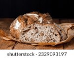 Traditional sourdough bread with nuts sliced on a rustic wooden background, close up. 