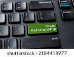 Small photo of Toxic relationship words on the green enter key of a desktop computer keyboard. Concept of unsupported, misunderstood, demeaned relationship on the Internet. Destructive online communication. Top view