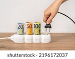 Small photo of Woman hand putting electric plug into power strip with rolled euro currency banknotes. Soaring of electricity prices in Europe. Electric bill increases, power price spike concept. Front view.