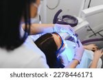 Small photo of Girl patient in the dental clinic. Teeth whitening UV lamp with photopolymer composition