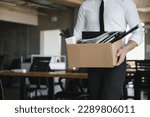 Small photo of Sad Fired. Let Go Office Worker Packs His Belongings into Cardboard Box and Leaves Office. Workforce Reduction, Downsizing, Reorganization, Restructuring, Outsourcing. Mass Unemployment Market Crisis.