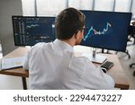 Successful trader in formalwear checking cryptocurrency information data on finance market graph, working in office.