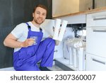 Small photo of Plumber installs or change water filter. Replacement aqua filter. Repairman installing water filter cartridges in a kitchen. Installation of reverse osmosis water purification system