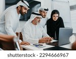 Group of middle-eastern corporate business people wearing traditional emirati clothes meeting in the office in Dubai - Business team working and brainstorming in the UAE