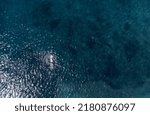 Aerial top view of a senior man swimming in the sea.