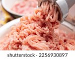 Twist farf in a meat grinder. Minced chicken comes out of the meat grinder at home. Cooking stocks of minced meat at home